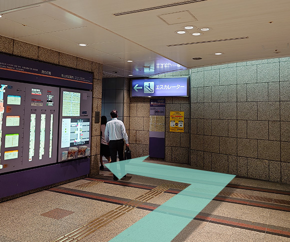 北8番出口のエスカレーターで上に上がります。
