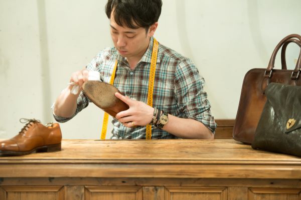 靴の汚れを丁寧に拭き取る